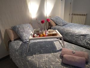 马德里COZY APARTAMENT 10 MINUTES FROM THE HEART OF MADRID的一间卧室配有一张床和一张鲜花桌子