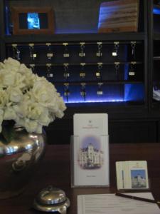 卡尔斯鲁厄马克格拉弗勒酒店的一张桌子,上面有花瓶和一张卡片