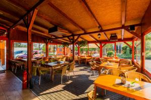 梅尔尼克Penzion Piranha的餐厅设有木桌、椅子和窗户。