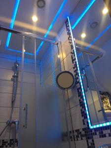 博帕德利烈瑞酒店的浴室设有镜子和带蓝色灯光的淋浴