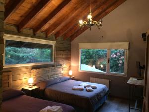 拉安戈斯图拉镇Hostería Las Cumbres的一间卧室设有两张床和两个窗户。