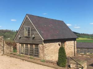 蒙默思Demesne Farm Guesthouse的一座黑色屋顶的小石头房子