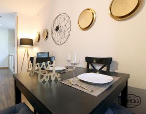 马德里Huertas Apartment - Estancias temporales的餐桌,配有盘子和两把椅子