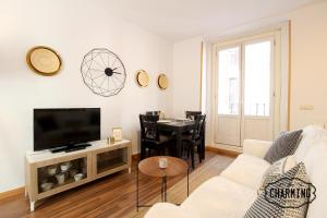 马德里Huertas Apartment - Estancias temporales的带沙发、电视和桌子的客厅