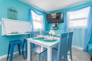 巴拿马城海滩Villa Paradise, Pet Friendly的蓝色的用餐室配有白色的桌子和椅子