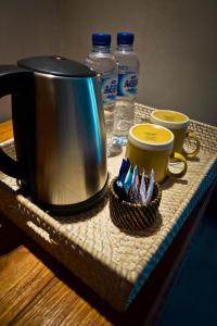 普卢坎Umadewi Surf & Retreat的托盘,内含两个咖啡杯和茶壶