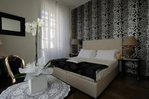 佛罗伦萨迪莫拉迪戈里安吉利奢华住宿加早餐旅馆的一间卧室配有一张黑色和白色壁纸的床