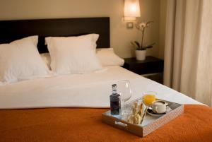 马德里别纳西班牙广场套房酒店的床上的食品和饮料托盘