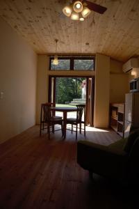 奈良鹿苑山庄山林小屋的一间带桌椅和窗户的用餐室