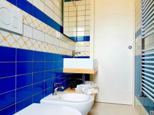 奥斯图尼B&B All'ombra degli ulivi的蓝色瓷砖浴室设有水槽和卫生间