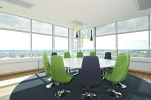 林雪平Sky Hotel Apartments Tornet的一间会议室,配有桌子和绿色椅子