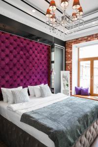 基辅塞尔特精品公寓酒店的一间卧室配有一张大床和紫色墙壁