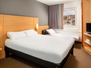 利物浦宜必思利物浦中心阿尔伯特码头 - Liverpool One购物中心酒店的酒店客房设有两张床和窗户。