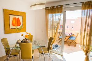 科拉雷侯Apartment Delfines Sand Corralejo By Holidays Home的一间设有玻璃桌和黄色椅子的用餐室