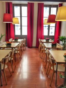 波尔多Hotel Gambetta的一间带桌椅和红色窗帘的餐厅