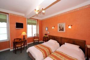 圣夫洛朗坦LOGIS - Hôtel Restaurant Les Tilleuls的一间卧室配有两张床、一张桌子和一台电视。