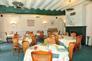 圣夫洛朗坦LOGIS - Hôtel Restaurant Les Tilleuls的大型用餐室配有桌椅