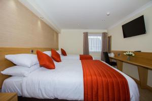 罗塞斯Hill Park Hotel的酒店客房配有一张带红色枕头的大床