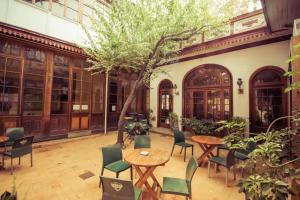圣地亚哥拉卡莎罗亚旅馆的庭院配有桌椅和一棵树