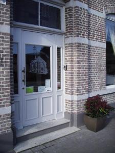 哈蒙特胡盖斯酒店的砖砌建筑上一扇带窗户的白色门