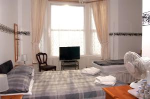 布莱克浦谢珀顿酒店的一间卧室设有两张床、一台电视和一扇窗户。