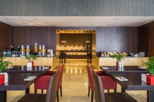 里斯本都市HF菲尼克斯酒店的餐厅设有黑色桌子和红色椅子