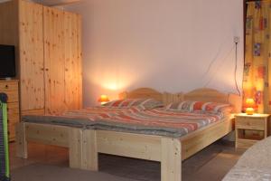 SzalafőOrbán Porta的一间卧室配有一张带两盏灯的木床。
