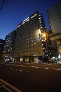 大阪多美迎大阪谷町酒店的前面有路灯的高楼