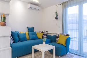 布德瓦Apartment Novak的客厅配有蓝色的沙发和两把椅子
