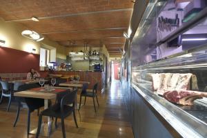 比萨Locanda La Bottega del Parco的一间带桌椅和柜台的餐厅