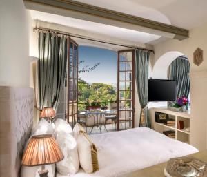 滨海卡涅卡纳德城堡酒店的一间卧室设有一张床,享有阳台的景色