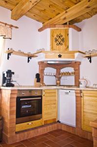 KercaszomorHarmatcsepp-Vendégház的厨房配有木制橱柜和炉灶。