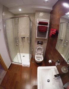 布德瓦Red Lux的带淋浴、卫生间和盥洗盆的浴室