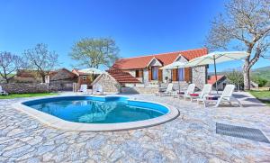 BiorineDalmatia Stone House - heated pool的一个带椅子的游泳池以及一座房子