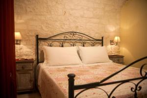 洛科罗通多卡拉肖内阿普利亚别墅酒店的一间卧室配有一张带2个床头柜和2盏灯的床。