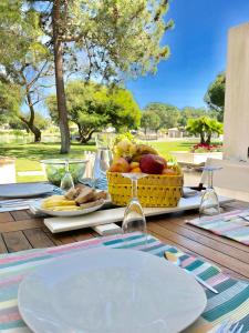 特罗亚Soltroia lake Dream house的野餐桌上放着一篮水果