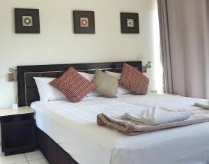 黄金海岸嘉德兰汽车旅馆和El Jays假日酒店的一张带红色和白色枕头的床