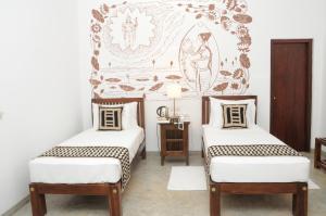 贾夫纳Jaffna Heritage Villa的壁画客房内的两张单人床