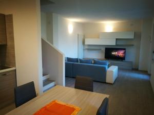 莱德罗Appartamento Chiara的客厅配有蓝色的沙发和电视