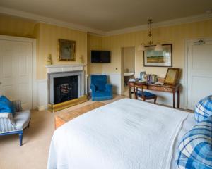 吉伦格雷沃思&谢若克斯酒店的一间卧室配有一张床、一张桌子和一个壁炉