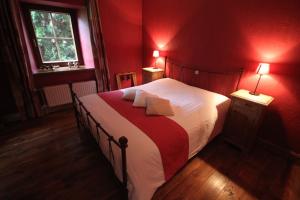 杜柏Comme à la Ferme的一间卧室设有一张带红色墙壁的大床