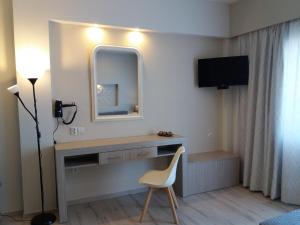 Ágios DimítriosIrida Studios的客房设有带镜子和椅子的书桌