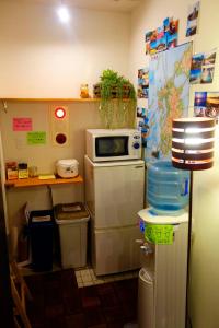 福冈Fukuoka Tabiji Hostel & Guesthouse的小厨房配有冰箱上方的微波炉