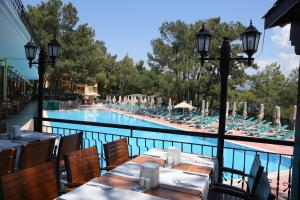 马尔马里斯Marmaris Park Hotel的游泳池旁的餐厅配有桌椅