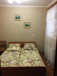 科松Sadyba u Mykhaila的卧室内的一张床铺,墙上有两张照片