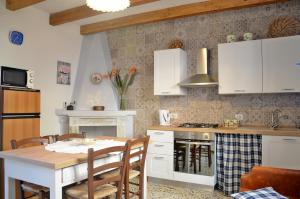 包内伊Guest House Sa Succargia的厨房配有白色橱柜和桌椅