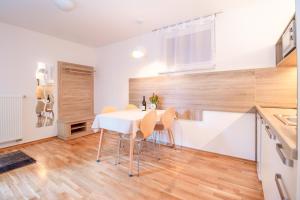 拉多夫吉卡Alp Apartma的厨房以及带白色桌椅的用餐室。