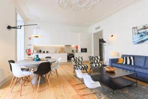 里斯本Bacalhoeiros 99 - Beautiful and bright Apartment @ Baixa, Chiado的客厅配有蓝色的沙发、桌子和椅子