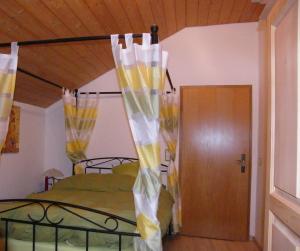 伊萨尔河畔兰道Ferienhaus Landau的一间卧室配有黄色和白色窗帘的床