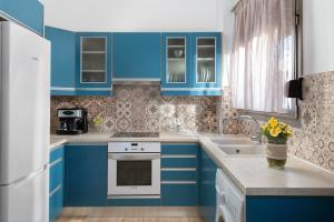 迪亚法尼villa Diafani, Εirini的蓝色的厨房配有白色家电和蓝色橱柜